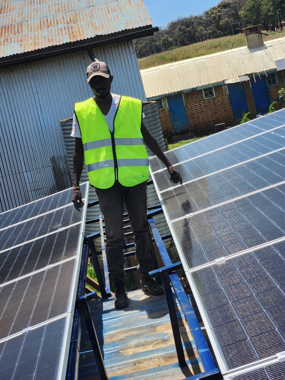 AFENERGY technician standing between two completed rooftop solar array rows