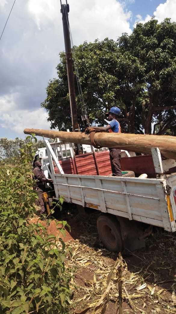 AFENERGY crew offloading distribution poles at a rural farm site