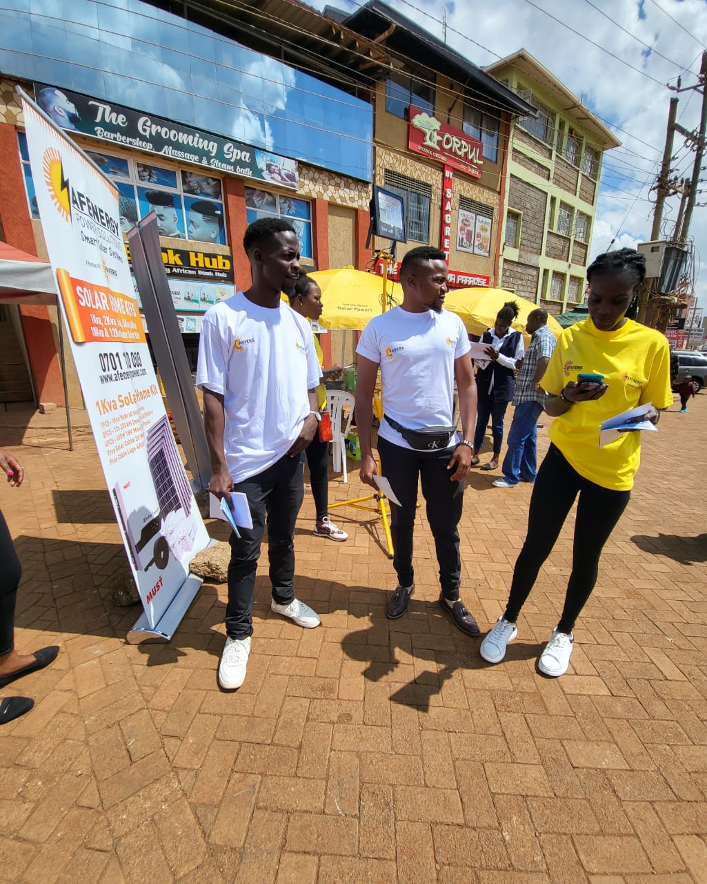 AFENERGY brand ambassadors beside a Solar Home Kits banner