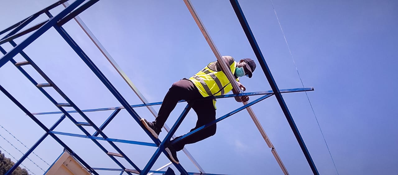AFENERGY fabricator securing a purlin on a container-mounted solar frame