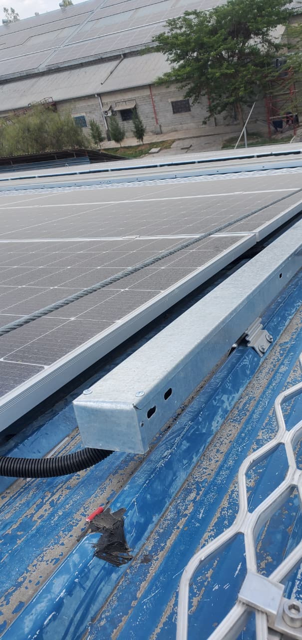 Galvanised cable tray and DC conduit routing beside a commercial rooftop solar array in Nairobi
