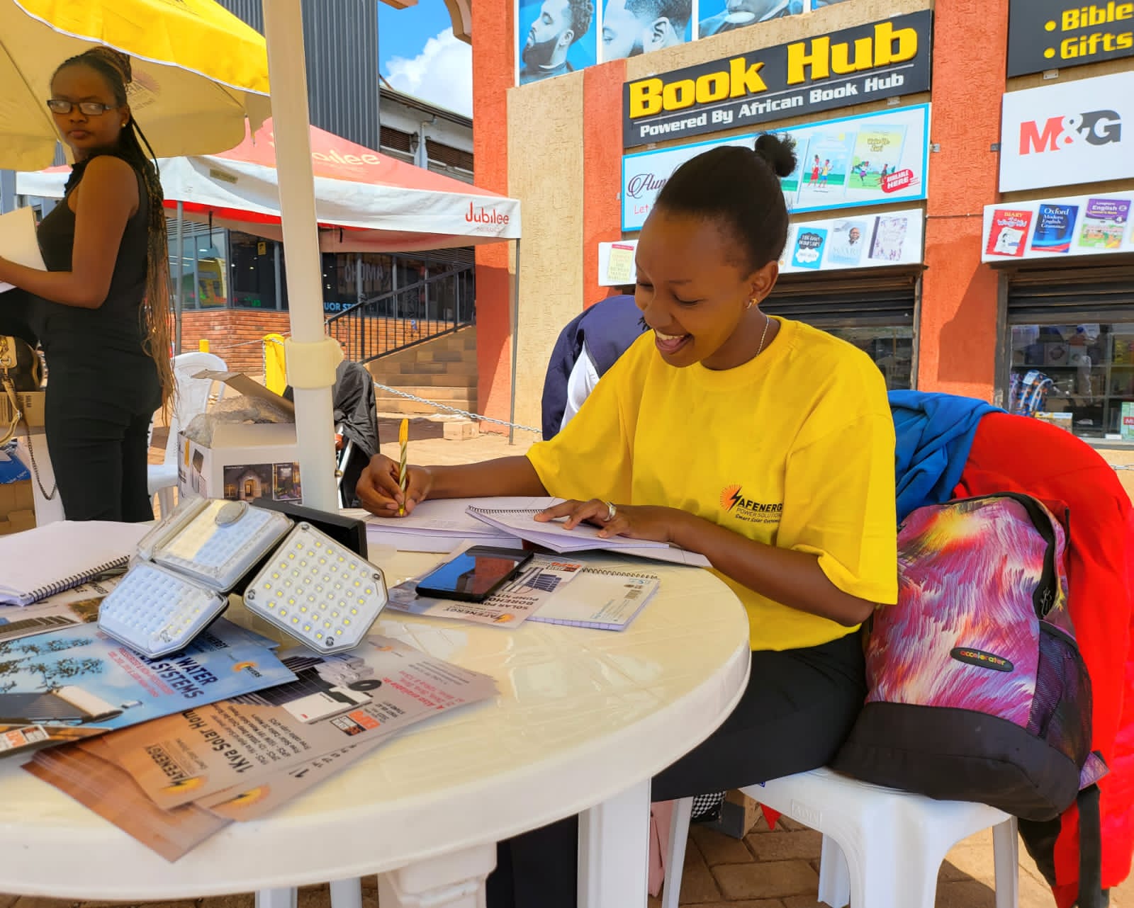 AFENERGY agent recording customer details beside solar floodlight samples