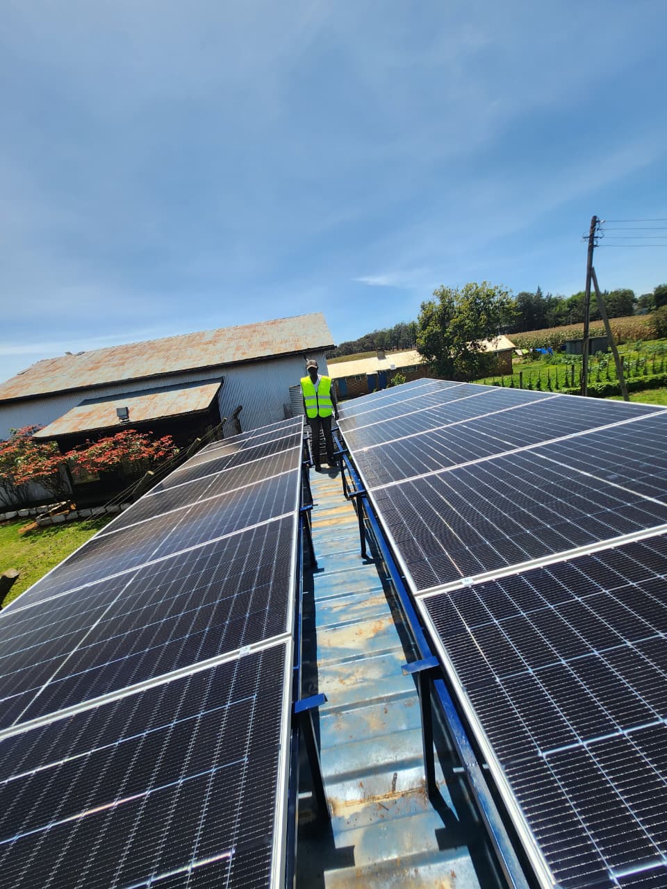AFENERGY technician walking the walkway between two rooftop solar array rows